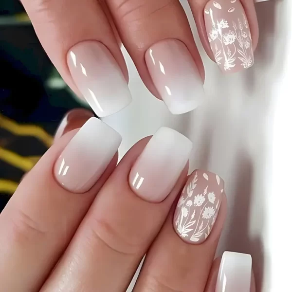 Short squoval press-on nails with a white floral design for an elegant, understated look.