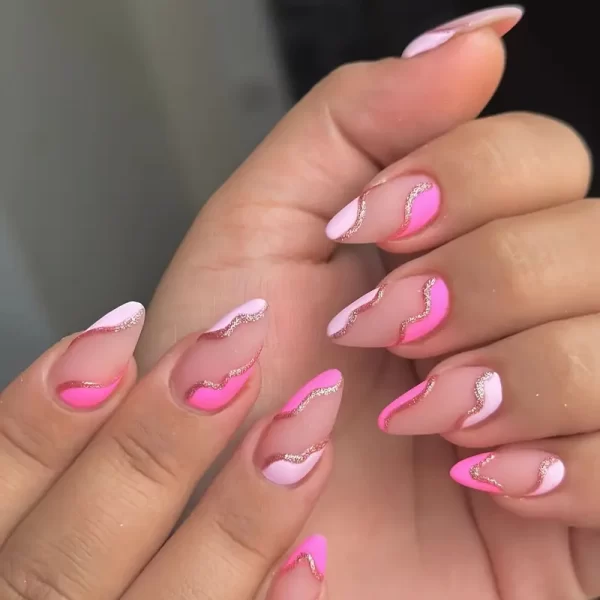 Long almond-shaped matte pink press-on nails with golden stripe design, includes nail file and adhesive pads.